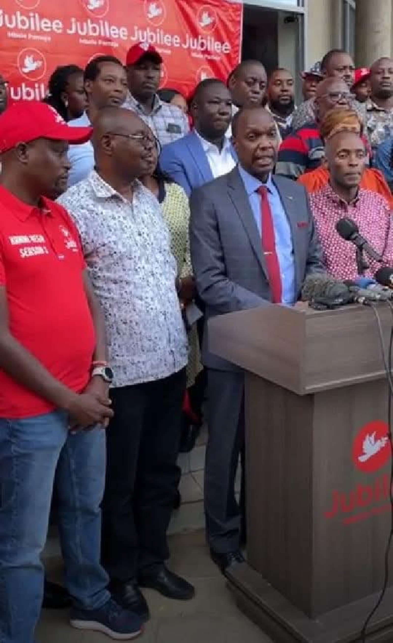 Kahara addressing a press briefing at a podium